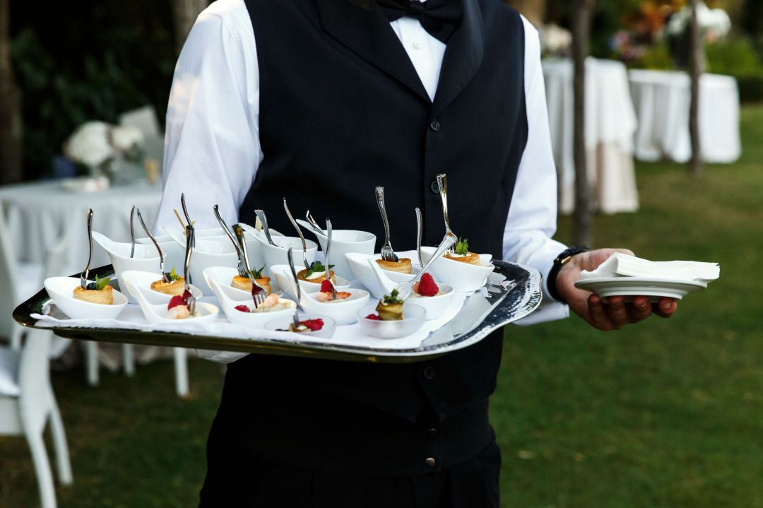 waiter-carries-plate-with-tasty-snacks